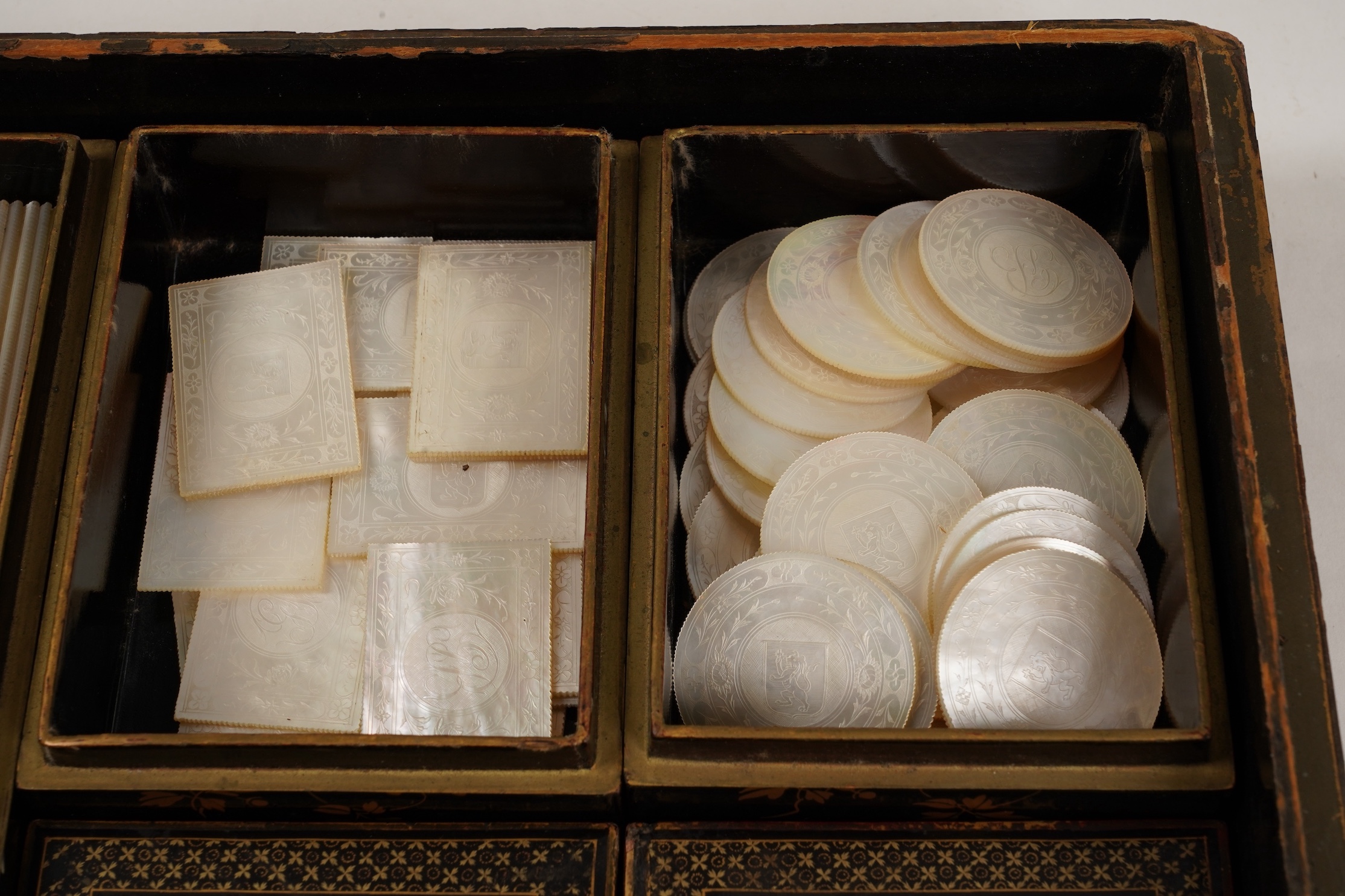Two Chinese gilt decorated black lacquer games boxes, containing numerous mother-of-pearl counters, 19th century